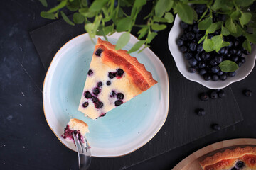 Homemade Blueberry Custard Pie. A piece of Blueberry Tart on a plate. 