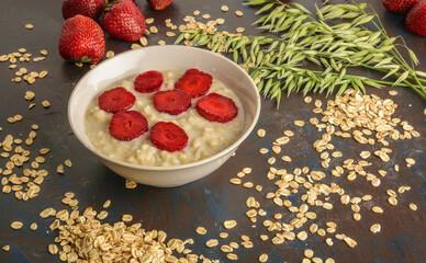 Bowl of oatmeal porridge with strawberry. Hot and healthy breakfast and diet food.