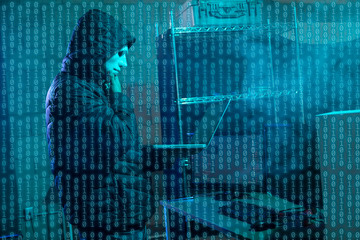 Hacker using laptop with binary code