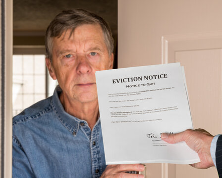 Open front door with man in suit handing an eviction notice to a defaulting renter in modern home due to missed rent