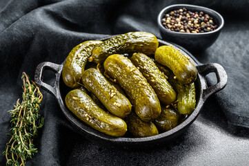 Marinated pickled cucumbers with herbs and spices. Black background. Top view