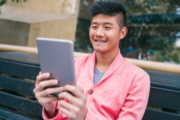 Asian man using his digital tablet.