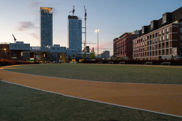 A view of an urban city park with skyscrapers in the background.