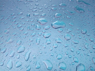 Water drops on the roof of the blue car as a background