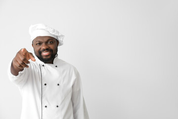 Male African-American chef pointing at viewer on white background