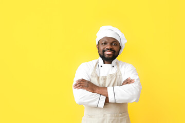 Male African-American chef on color background