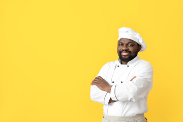 Male African-American chef on color background