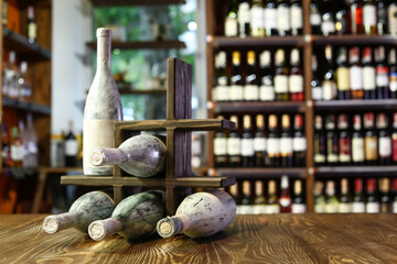 Holder with bottles of matured wine on table in store