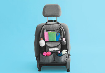 Travel organizer with different things on car seat against color background