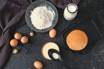 Composition with ingredients for pancakes on dark background