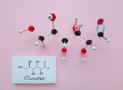 Molecular structure model and structural chemical formula of glucose molecule. D-Glucose (dextrose, blood sugar) is a simple sugar and it is the most abundant monosaccharide. Black=C, red=O, white=H.