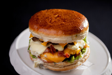 Foto em detalhe de um hamburguer com carne, queijo, molho.