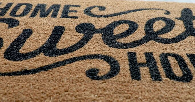 4k Pan Over Home Sweet Home Welcome Mat Resting on Floor