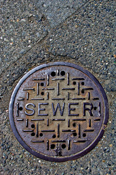 Old cast iron sewer manhole cover from bygone era, West Seattle, Washington 
