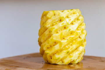 Whole peeled pineapple on a wooden cutting board - obrazy, fototapety, plakaty