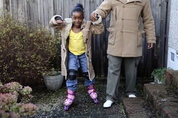 Girl holding her sister's hand while inline skating