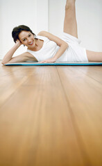 Obraz premium Woman lying on yoga mat