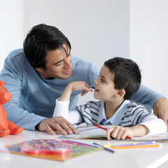 Father watching son doing homework