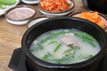 Korean pork rice soup (Dwaeji-gukbap) in a steaming stone bowl with the side dishes at Korean restaurant, Busan, South Korea