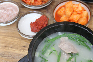 Korean pork rice soup (Dwaeji-gukbap) in a steaming stone bowl with the side dishes at Korean restaurant, Busan, South Korea