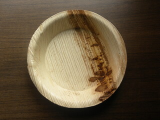 Small yellow and brown color bowl made of Areca palm leaf