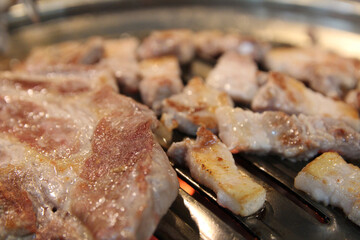 Korean grilled pork BBQ (Samgyeopsal-gui) with charcoal at Korean restaurant, Busan, South Korea