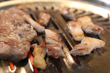 Korean grilled pork BBQ (Samgyeopsal-gui) with charcoal at Korean restaurant, Busan, South Korea