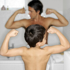 Fototapeta na wymiar Father and son showing off their muscular arms