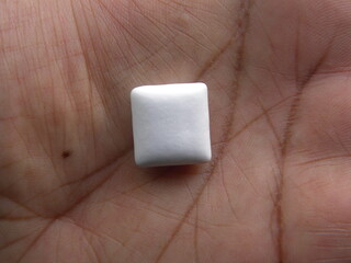 Obraz premium Small white Chewing gum on palm of hand