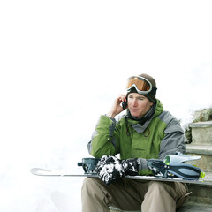 Male snowboarder talking on the phone