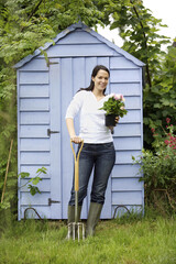 Woman with potted flower and spading fork