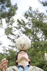 Boy balancing soccer ball on his head