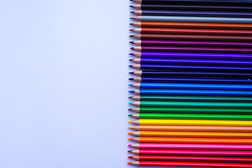 set of many colored pencils on a white background and copy space