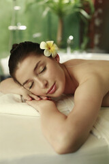 Obraz na płótnie Canvas Woman lying forward on the massage table with her eyes closed