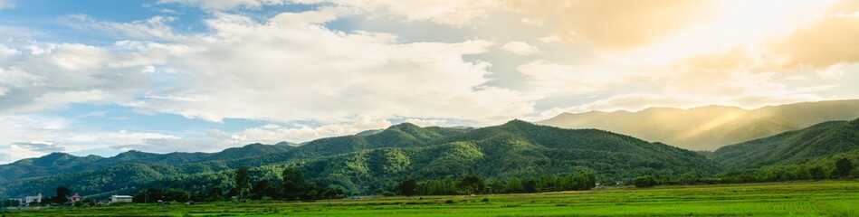 The beautiful panorama landscape of the green tree in the mountain, The sun's rays through at the top of the hill and the rain, Phayao Northern  Thailand.