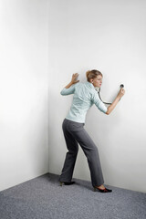 Businesswoman examining wall with the stethoscope