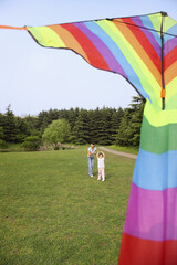 Girl and woman flying kite in the park