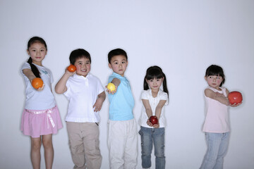 Obraz premium Children holding fruit in each of their hands