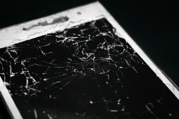 Heavily broken glass on a smartphone on a black background