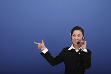 Businesswoman wearing headset gesturing to her right