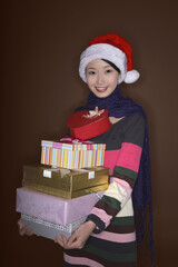 Woman with Christmas hat holding a stack of presents