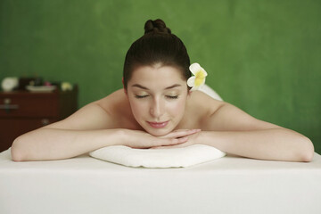 Obraz na płótnie Canvas Woman lying forward on the massage table with her eyes closed