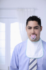 Businessman with baby bib and pacifier