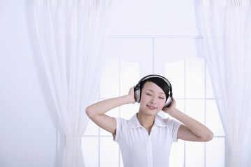 Woman listening to music on the headphones with her eyes closed