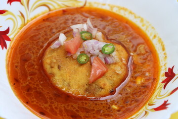 Kat vada, Kat wada or Batata vada sambar or Vada usal, spicy and tasty snack or breakfast, vada or potato patties served in a spicy sauce or curry, particularly in the marathi cuisine, Indian food