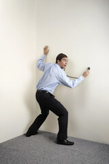 Businessman examining the wall using stethoscope