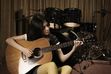 Naklejka premium Young woman playing guitar
