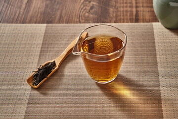 A clear glass with a hot cup of Pu-erh tea in it.