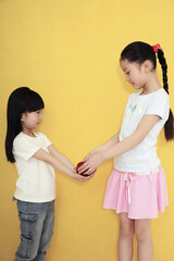 Girl giving apple to another girl