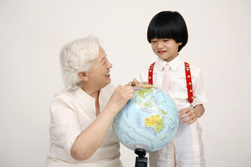 Boy and senior woman looking at globe